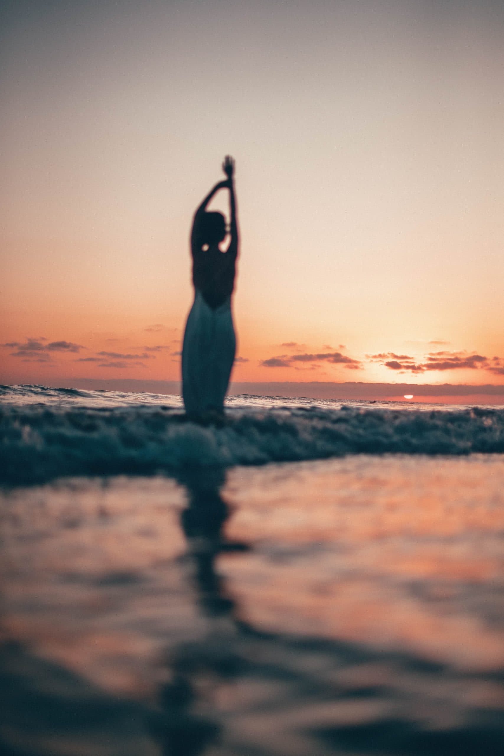 Erzengel Bedeutung Frau am Strand vor Sonnenuntergang