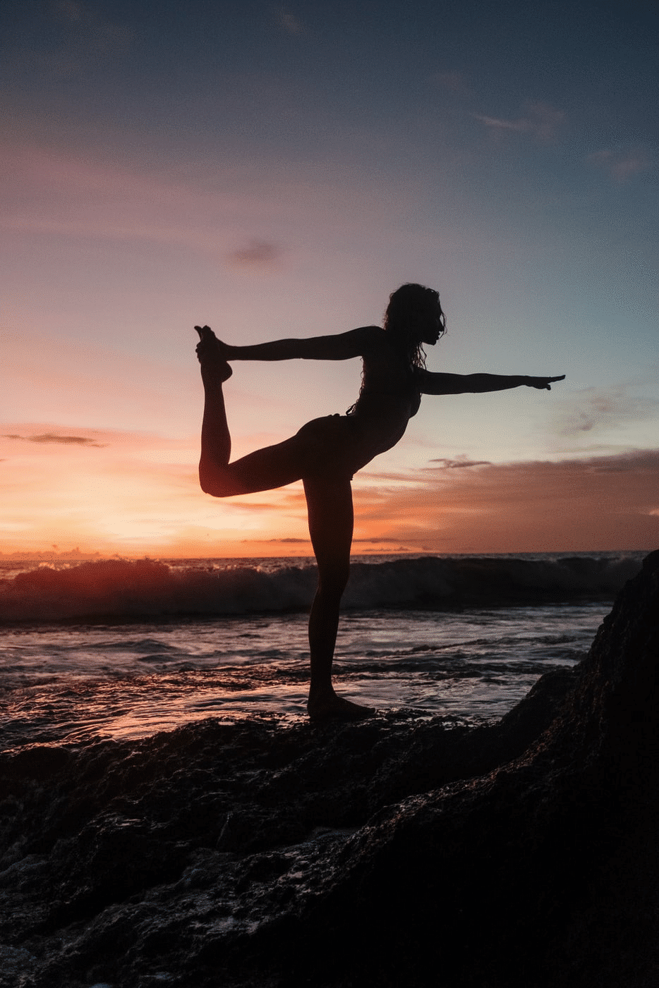 Frau Silhouette Yoga Yogagurt Yogaübungen am Strand vor Sonnenuntergang