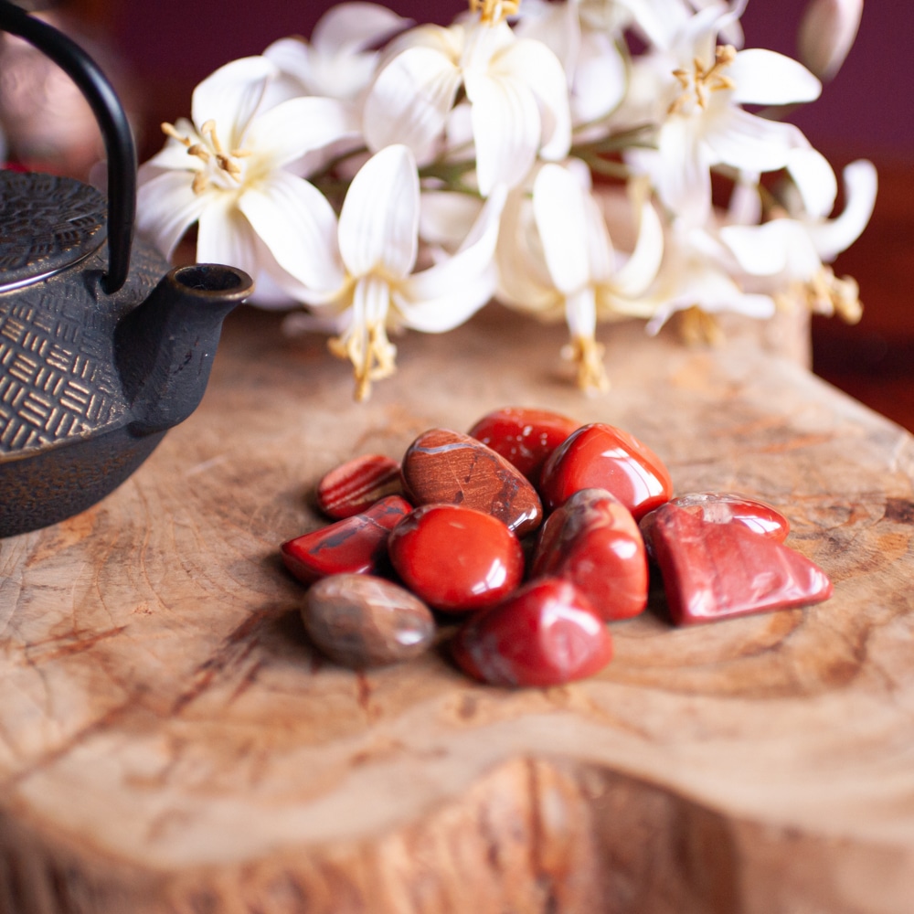 Mix rote Edelsteine auf Holz mit weißen Blumen und Teepott