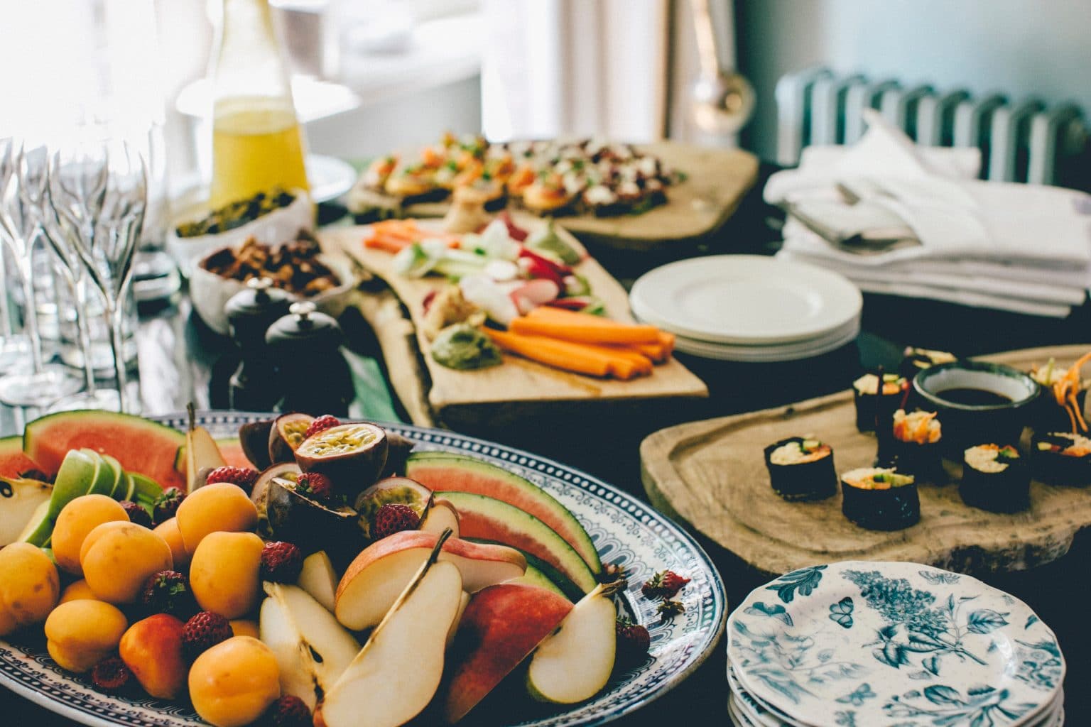 Tisch mitHäppchen Früchten und Sekt und Orangensaft mit Tellern und Besteck und Servietten 