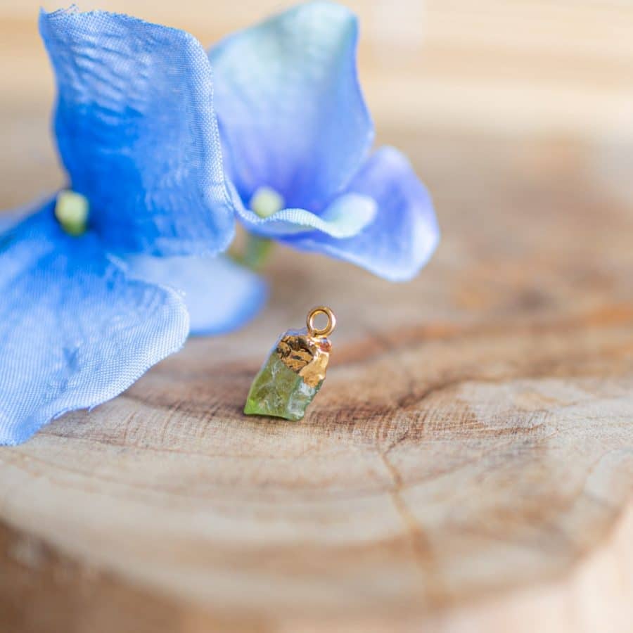 Stein Steinbock Peridot Edelstein Anhänger gold auf Holz mit Blumen