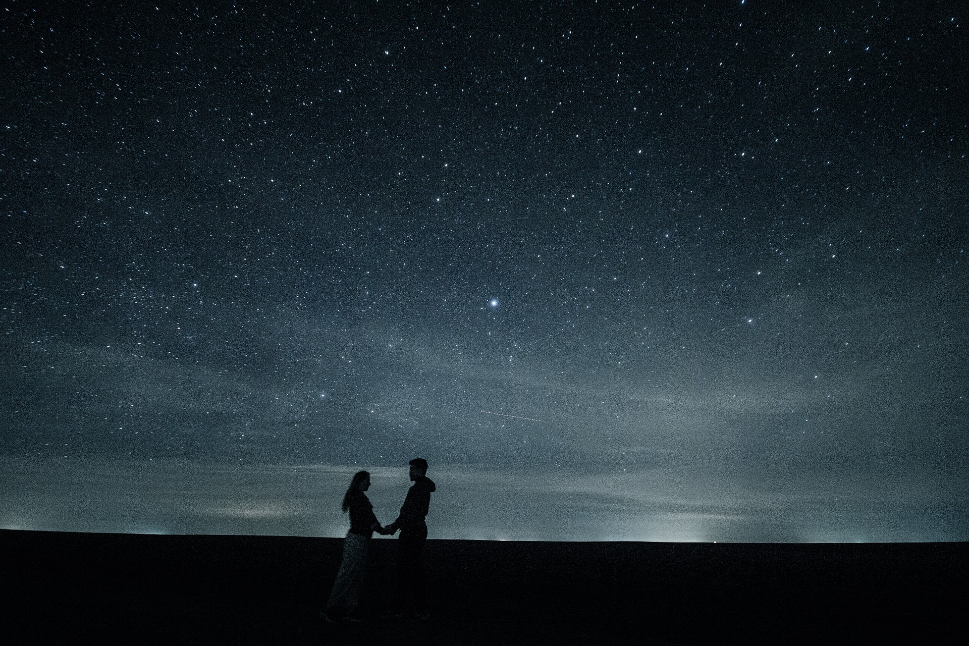 Händchen haltendes Paar Silhouette vor Sternenhimmel